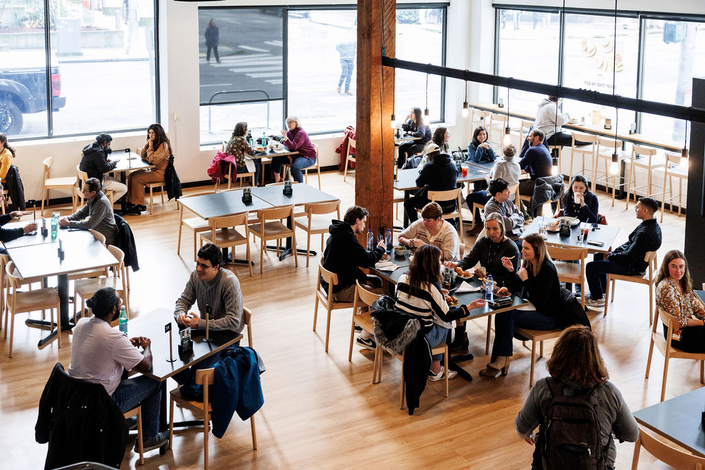 Customers sitting at tables eating and talking at the FareStart Restaurant